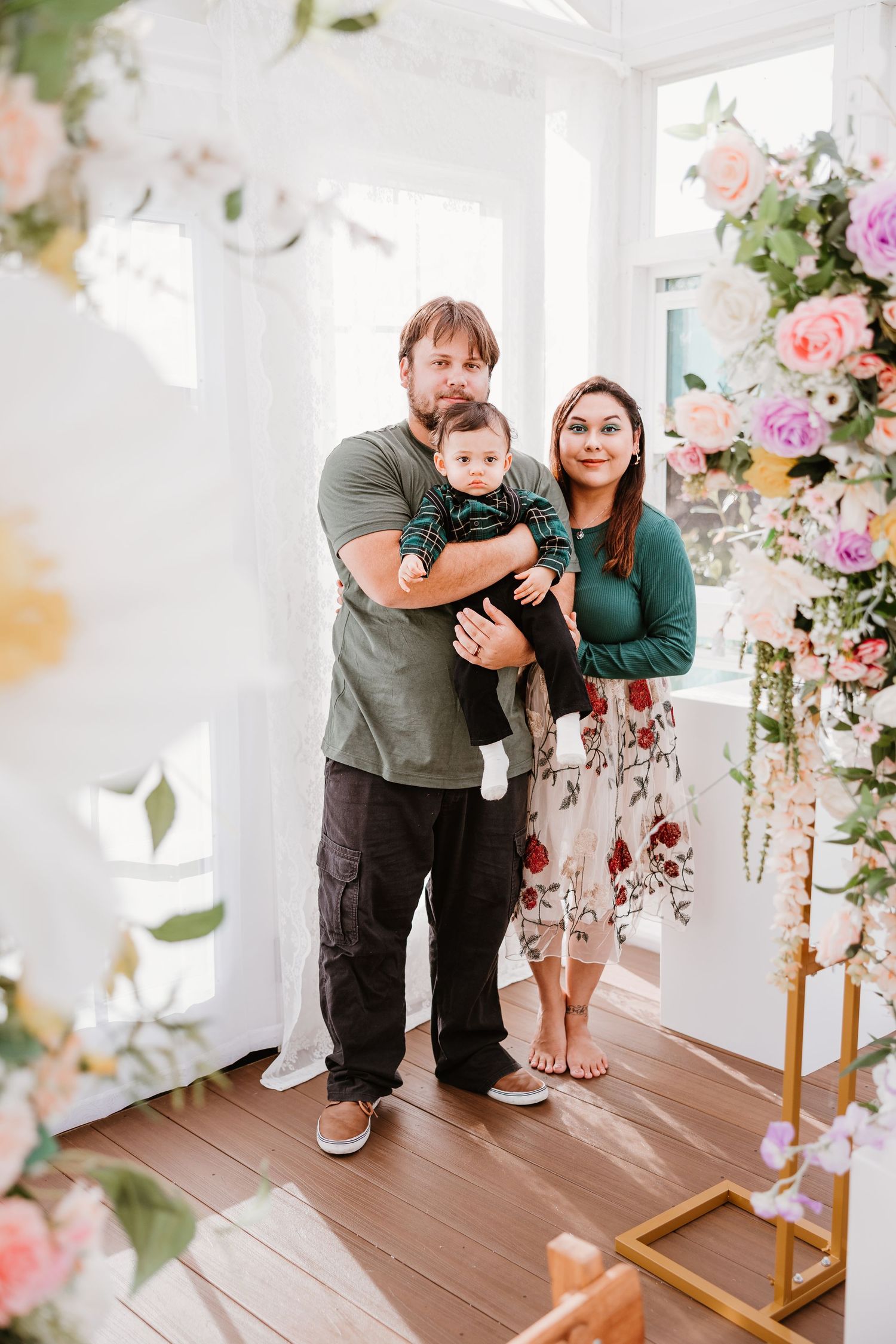 A casual family photo session with holiday decorations and tropical elements in the background.
