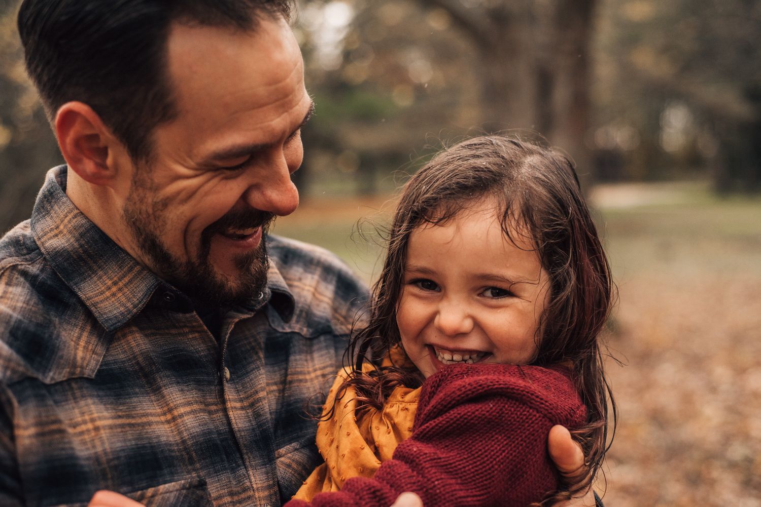 A heartwarming autumn moment shared while holding a bright orange maple leaf outdoors.