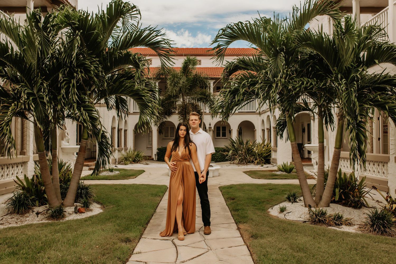 Elegant courtyard with palm trees and Spanish colonial architecture for wedding photos.
