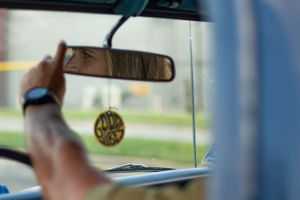 Interior view of classic car showing rearview mirror and dashboard details.