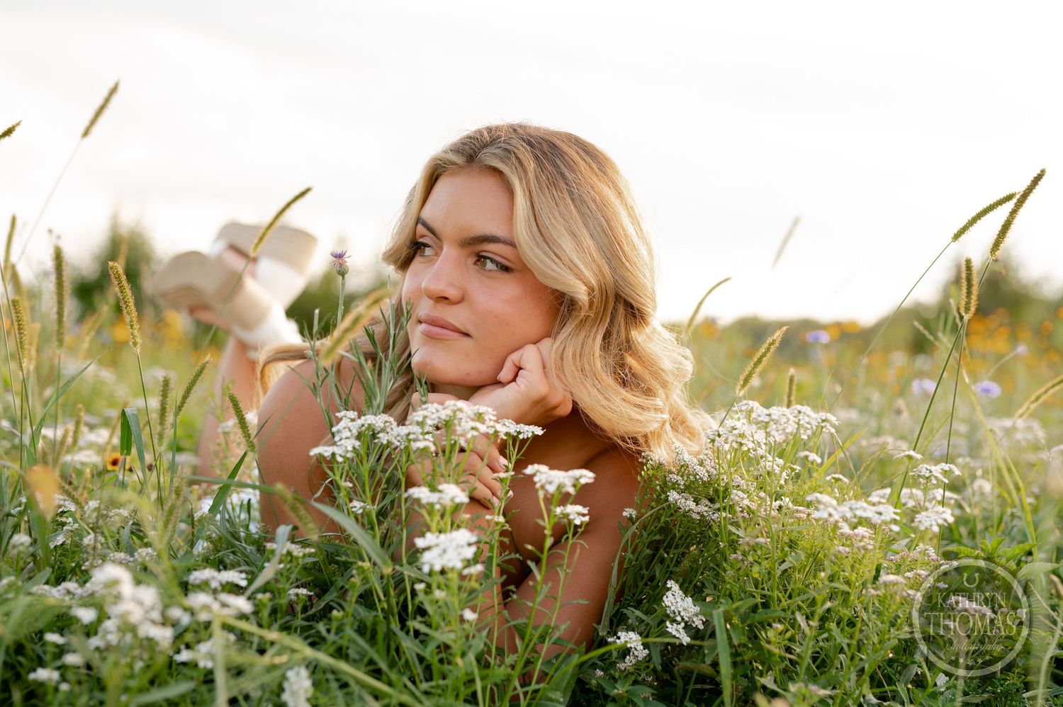 An artistic nature portrait taken among delicate white wildflowers and tall grass.
