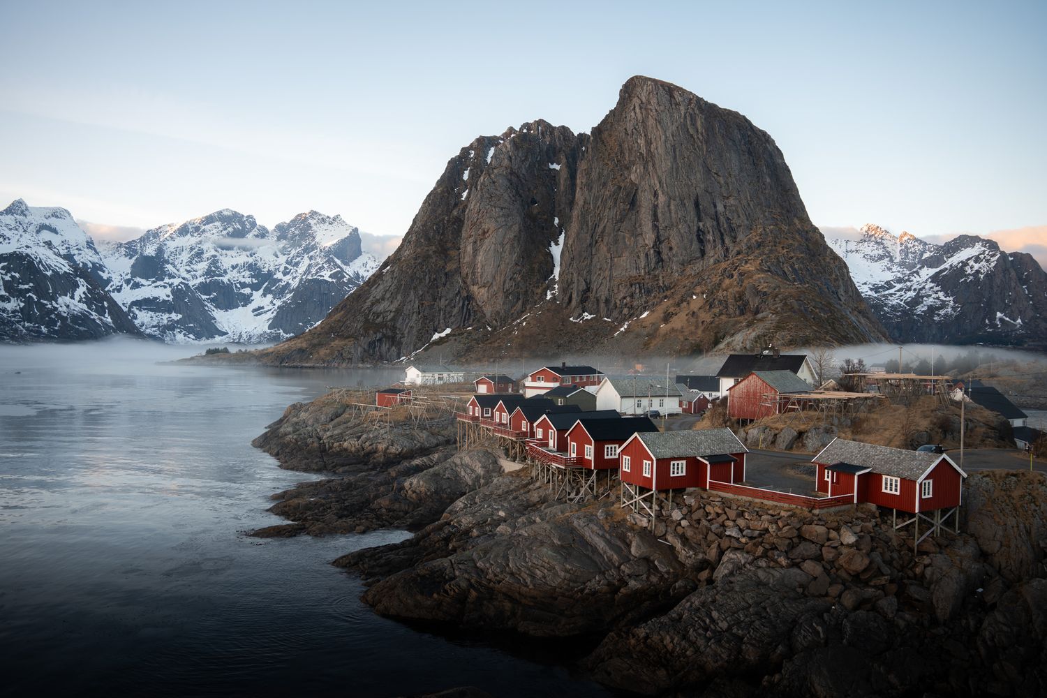 Hamnøy dans les iles lofoten en norvège pendant l'hiver avec les rorbuers rouges et la montagne enneigée en arrière plan