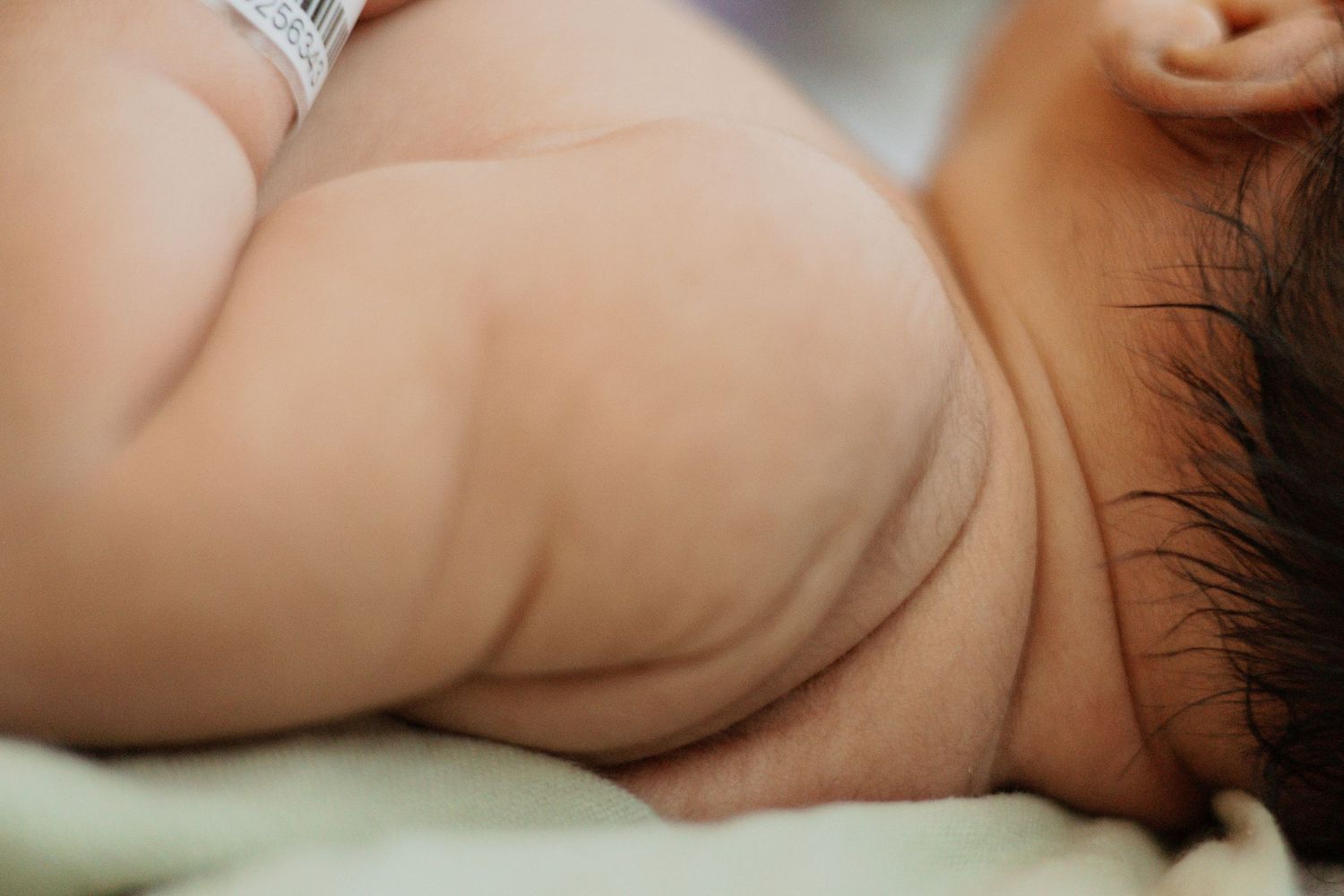 Close-up of a newborn baby's soft skin and shoulder.