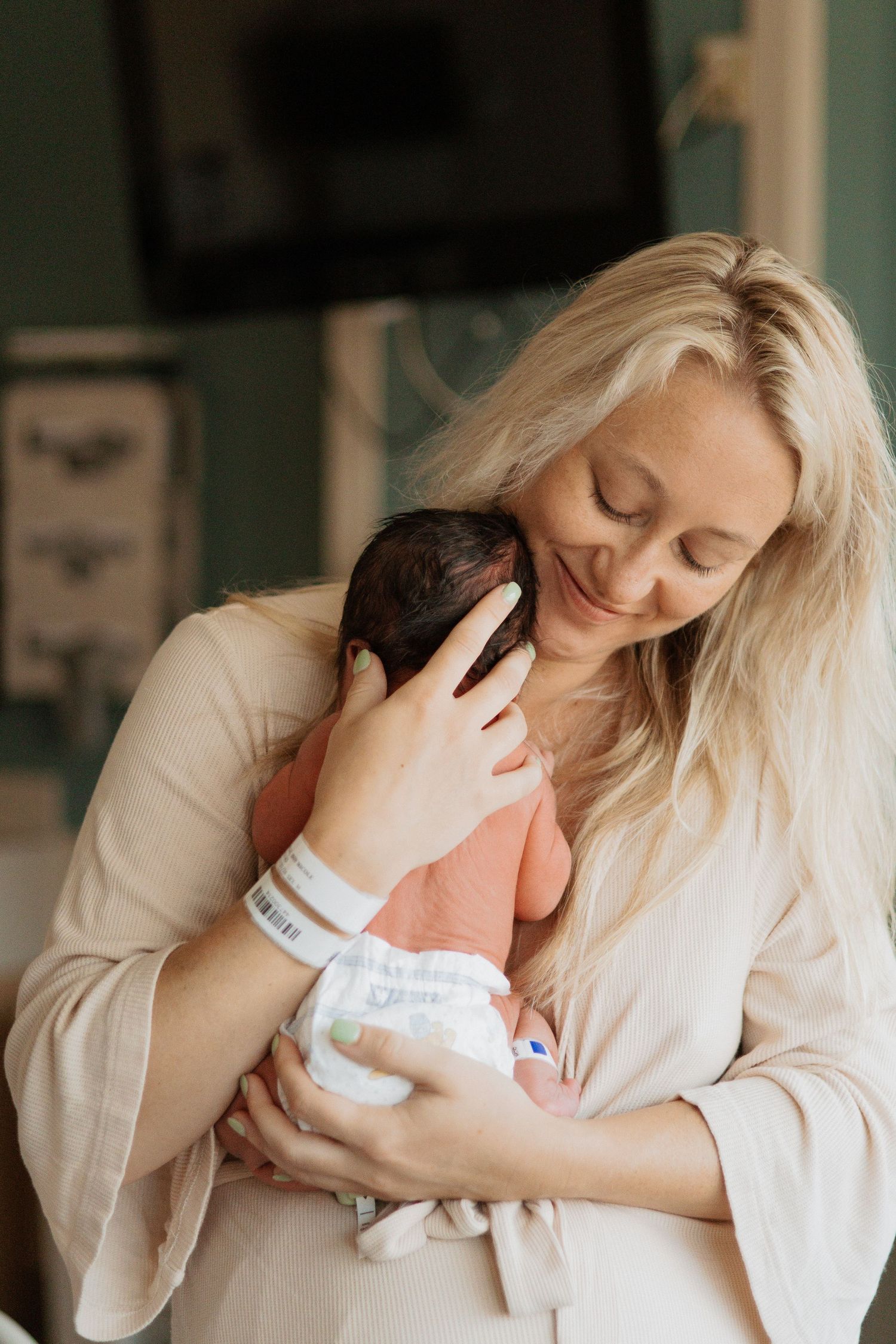 A peaceful cuddle with a newborn wearing hospital bracelet and wrapped in blankets.