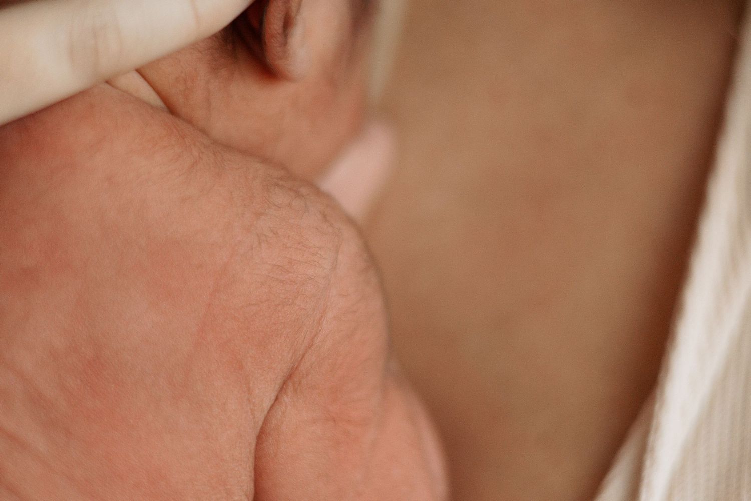 Close-up detail of newborn baby's delicate skin and shoulder.