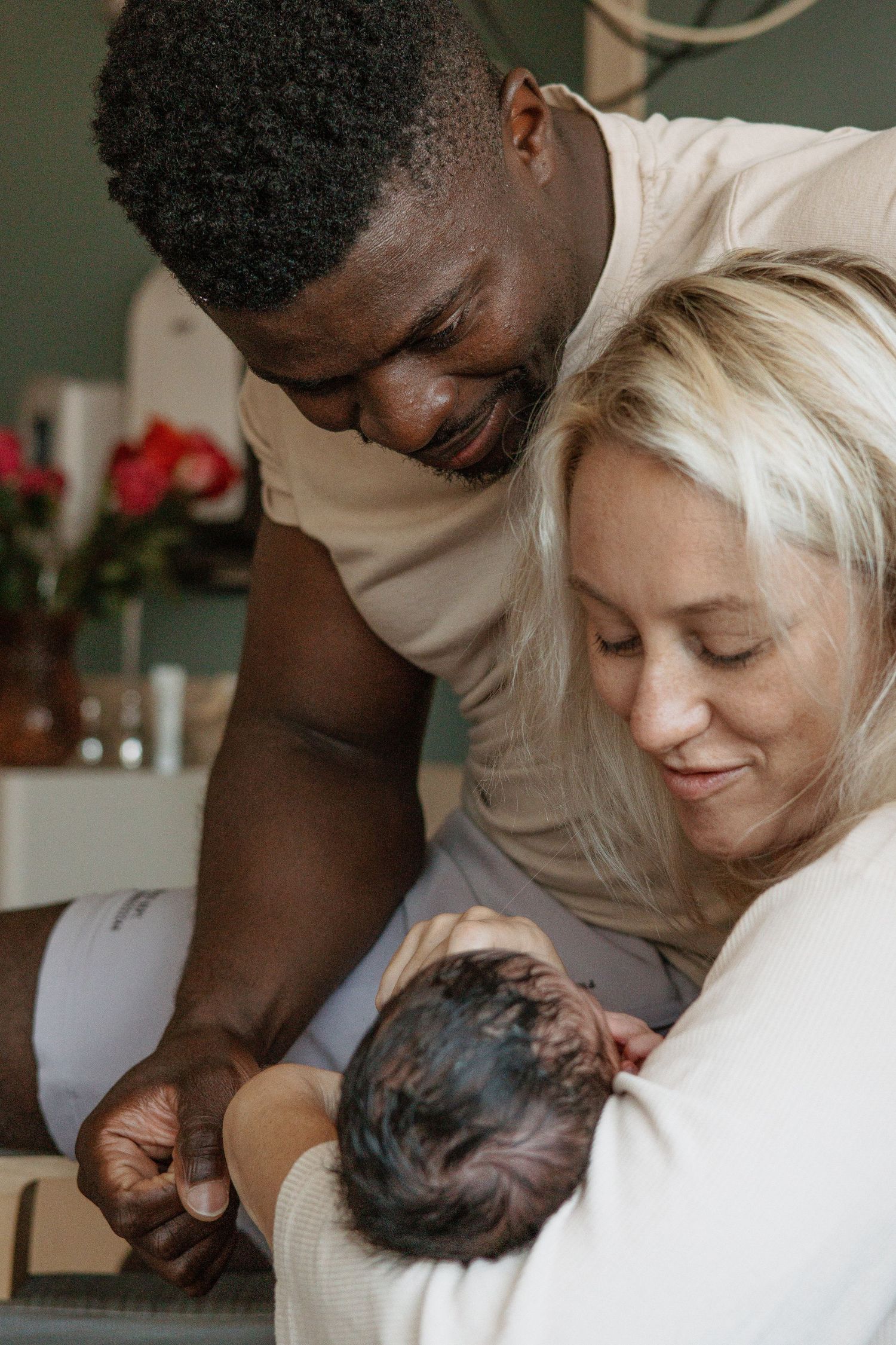 Loving parents sharing a tender moment with their newborn baby in hospital.