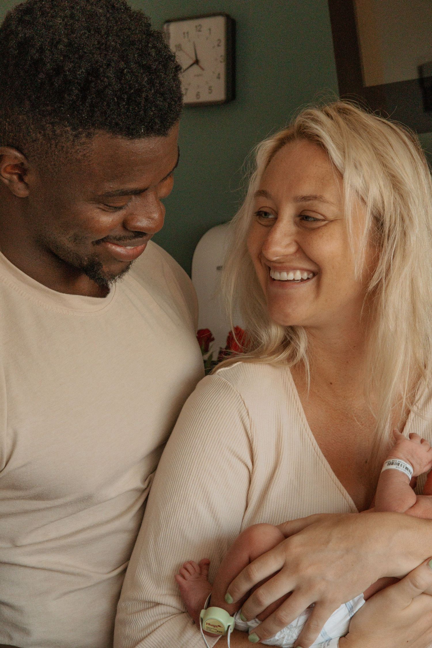 An intimate family moment showing pure joy and connection while holding their newborn.