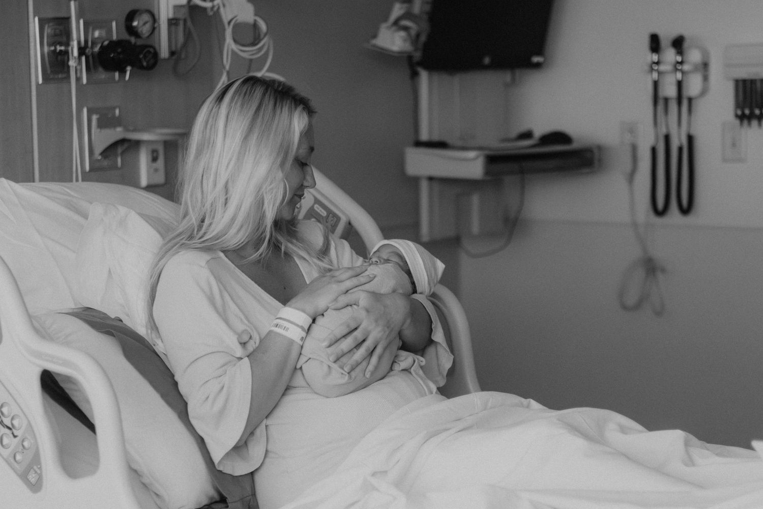 Maternal bonding moment captured in black and white hospital setting.