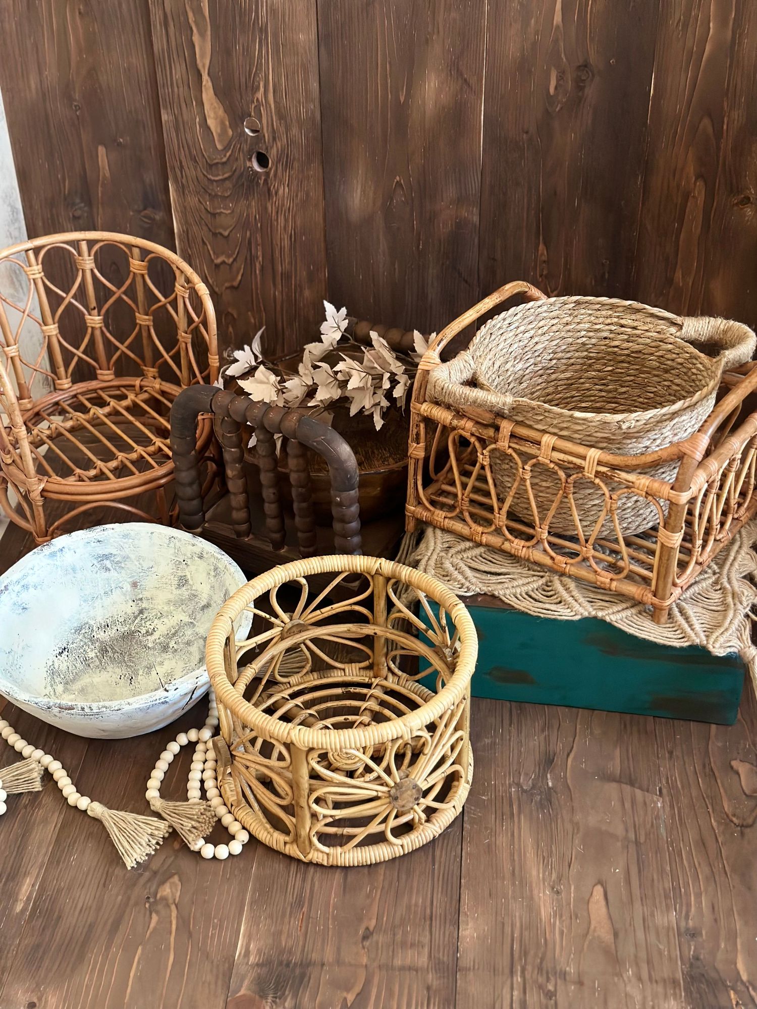 Rattan baskets and decorative items arranged against a dark wooden wall background.