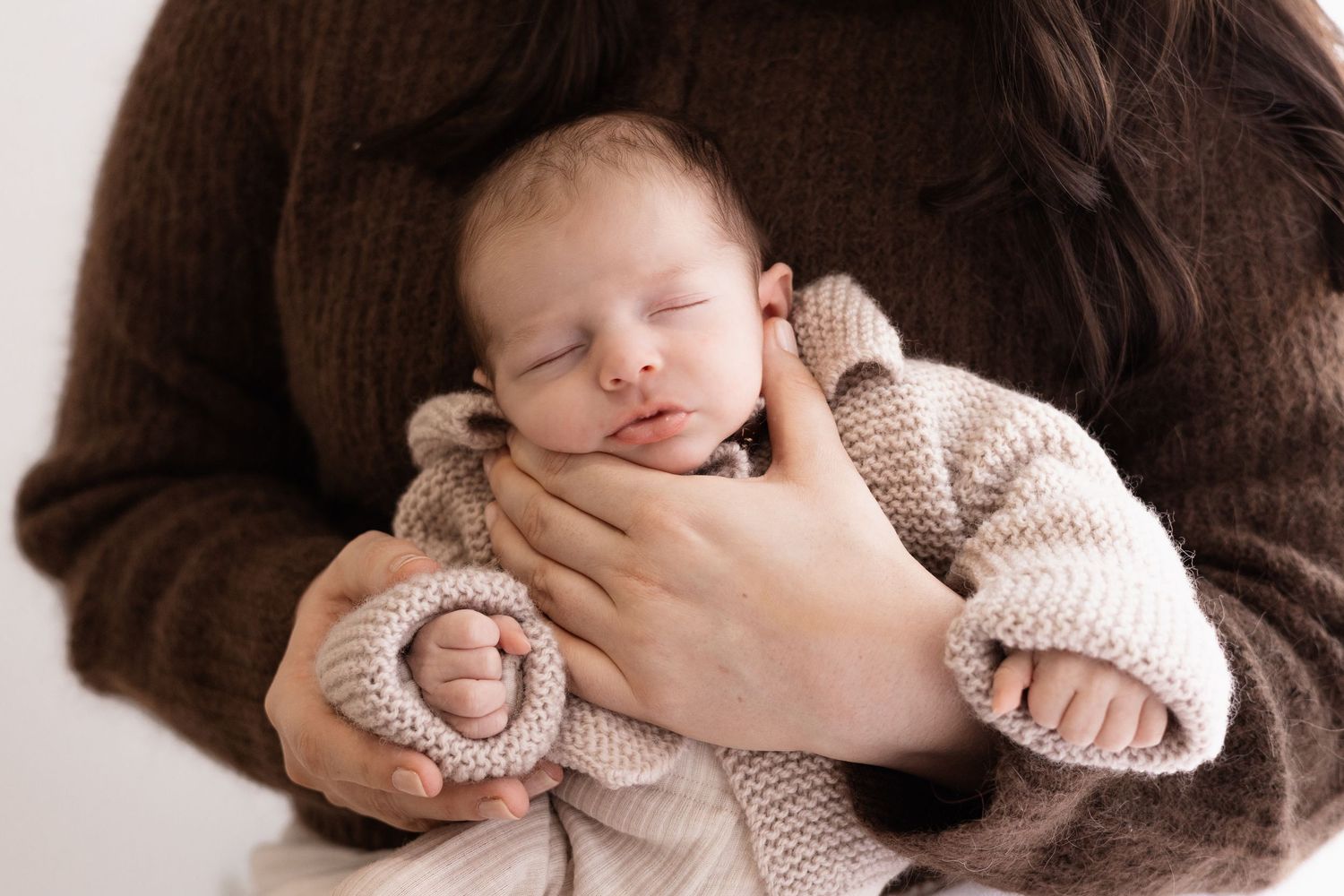 In home newborn session, dad holding onto baby in christchurch