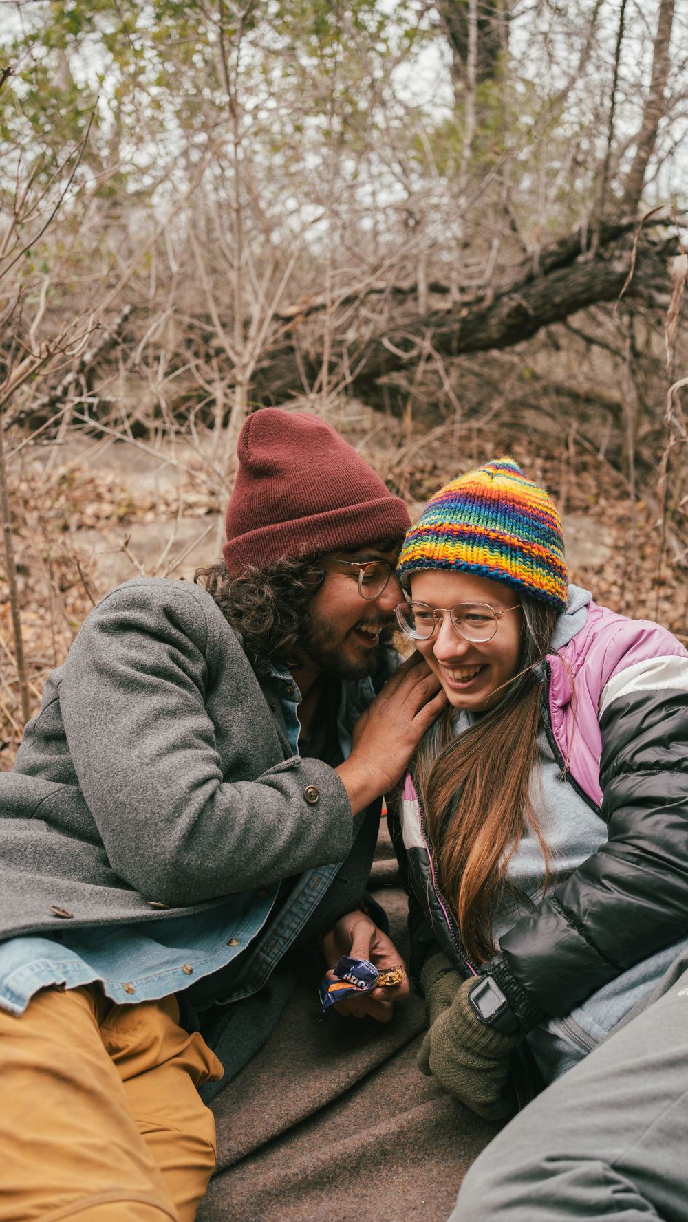 Two people in winter clothing share an intimate moment outdoors.