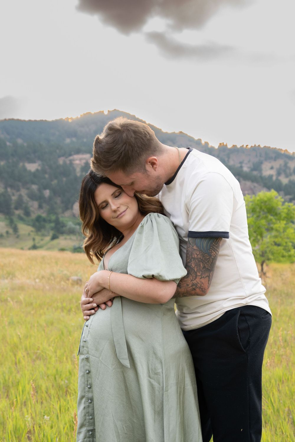 A loving embrace captured in a mountain meadow during golden hour.