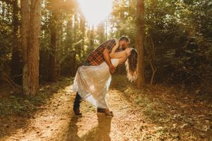 Romantic sunset photoshoot among tall trees with golden light filtering through.