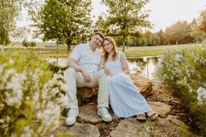 Couple sitting together on grass during golden hour sunset in a park.