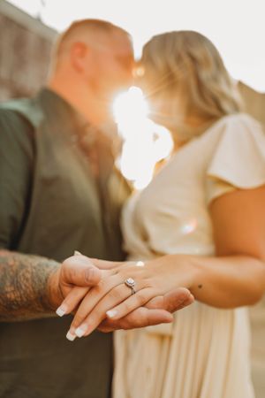 Close-up shots of hands and engagement ring in warm sunlight.