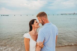 Intimate beach portraits of couple embracing by Lake Michigan.