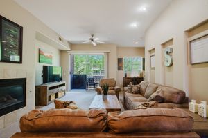 Modern living room with brown leather couches, fireplace, and TV centered around a comfortable seating area.