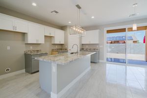 Contemporary kitchen featuring white cabinets, granite countertops, and stainless steel appliances.