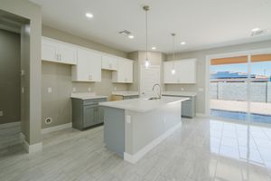 Modern white kitchen interior with gray tile floors, quartz countertops, and pendant lighting over a large center island.
