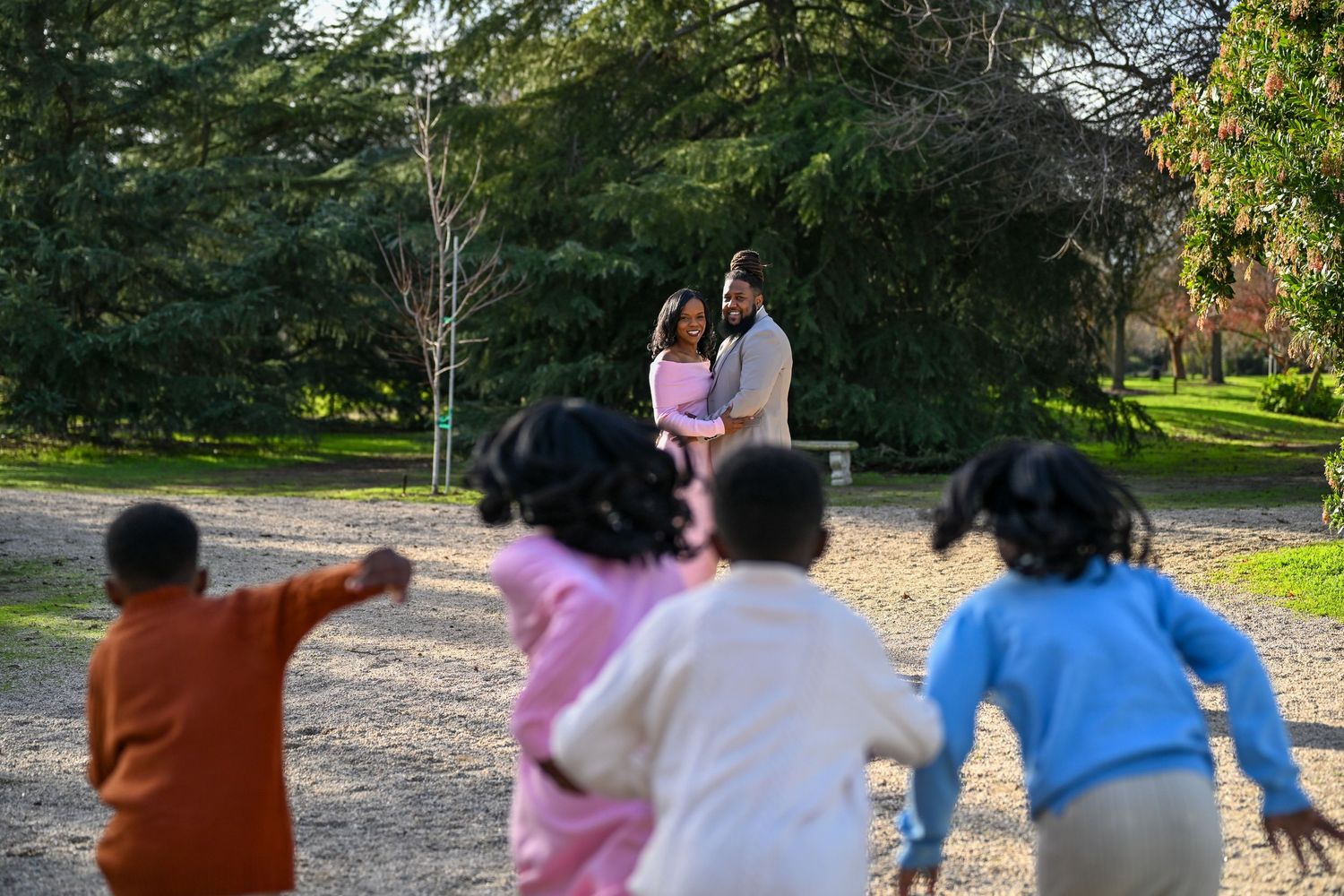 People walking together on a path through a lush green park on a sunny day.
