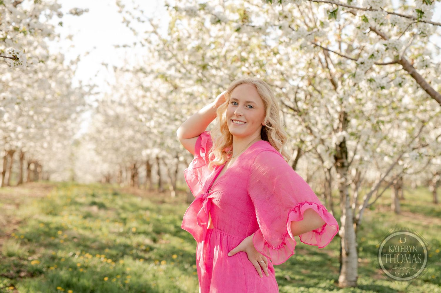 Portrait in a flowering orchard with soft sunlight filtering through white spring blossoms.
