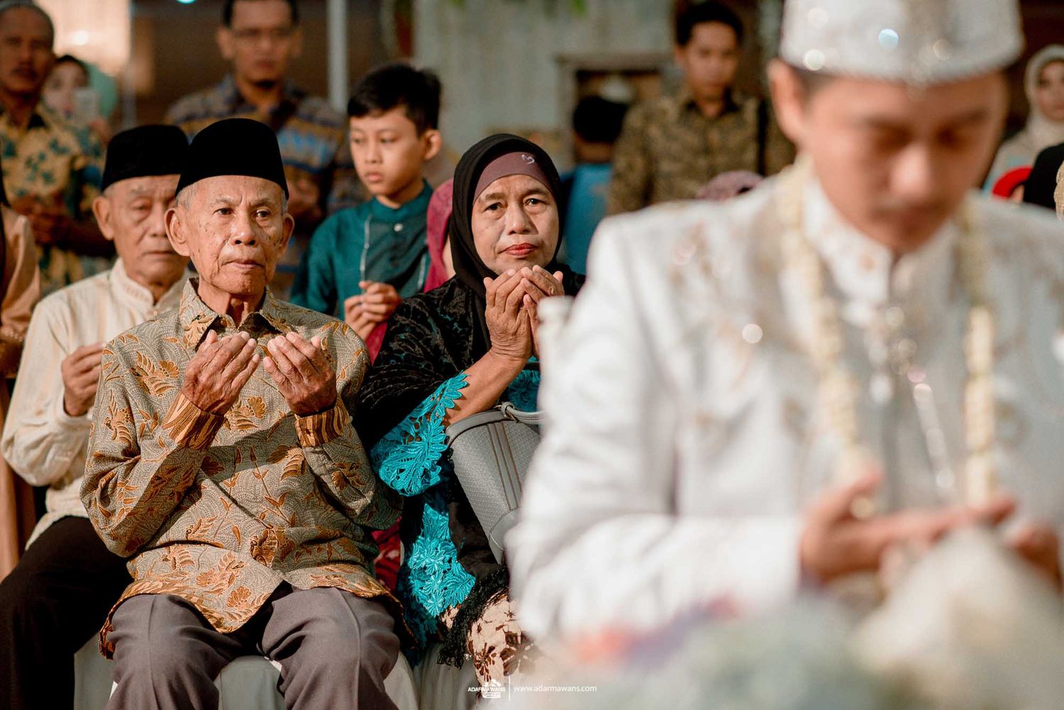 Guests praying during traditional Indonesian wedding ceremony.