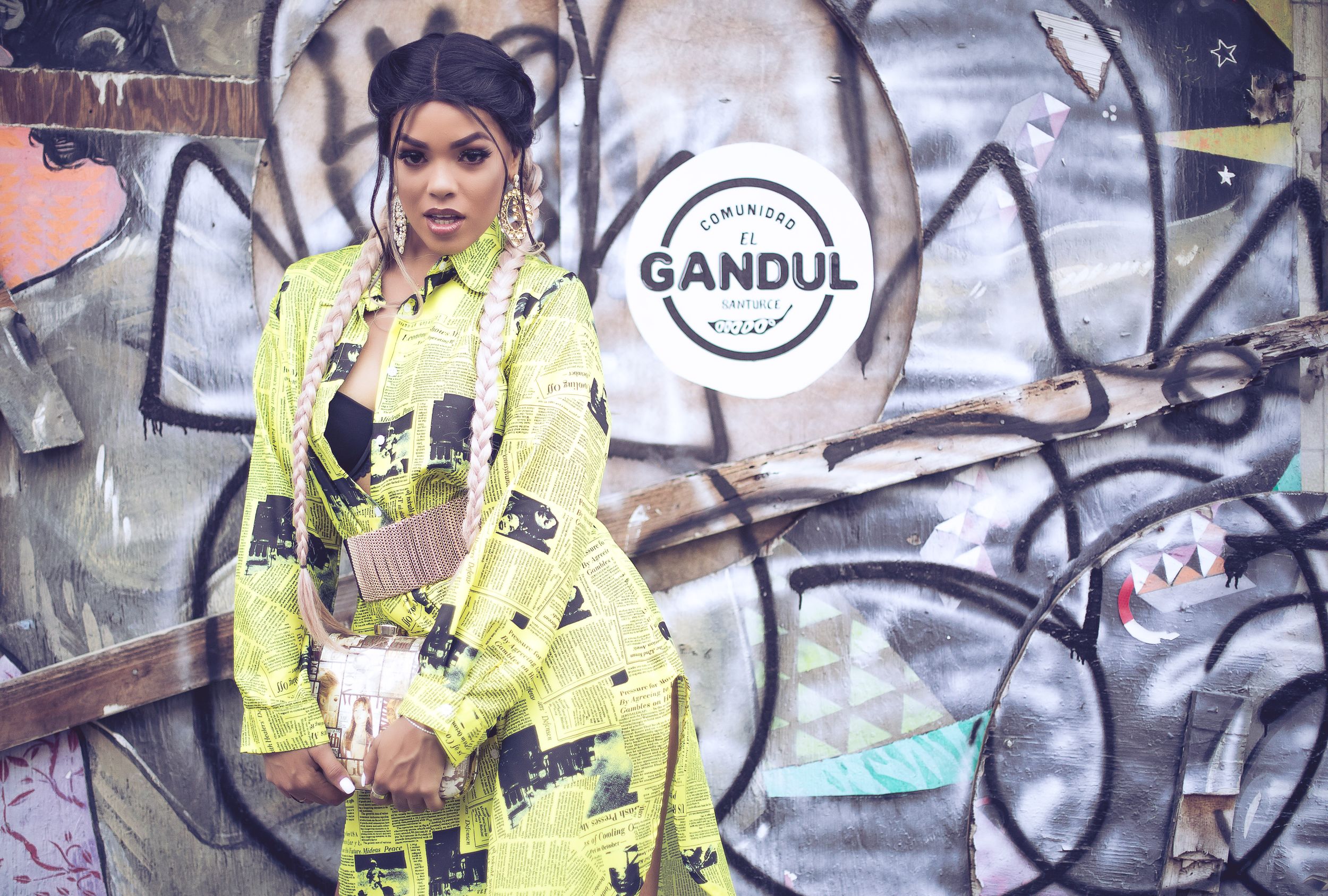 Fashion pose against graffiti wall wearing neon yellow outfit.