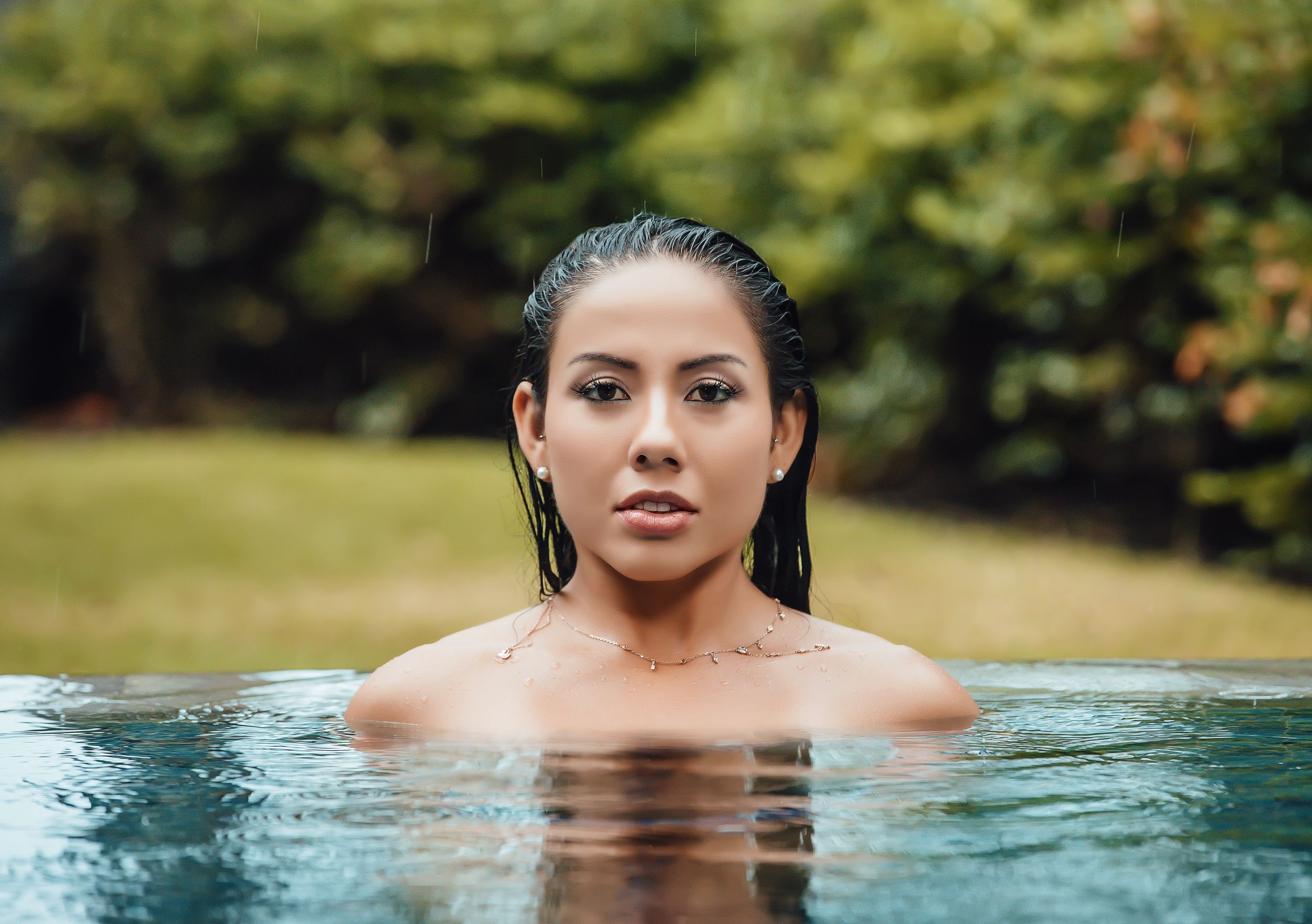 Portrait of woman in water with wet hair and natural lighting.