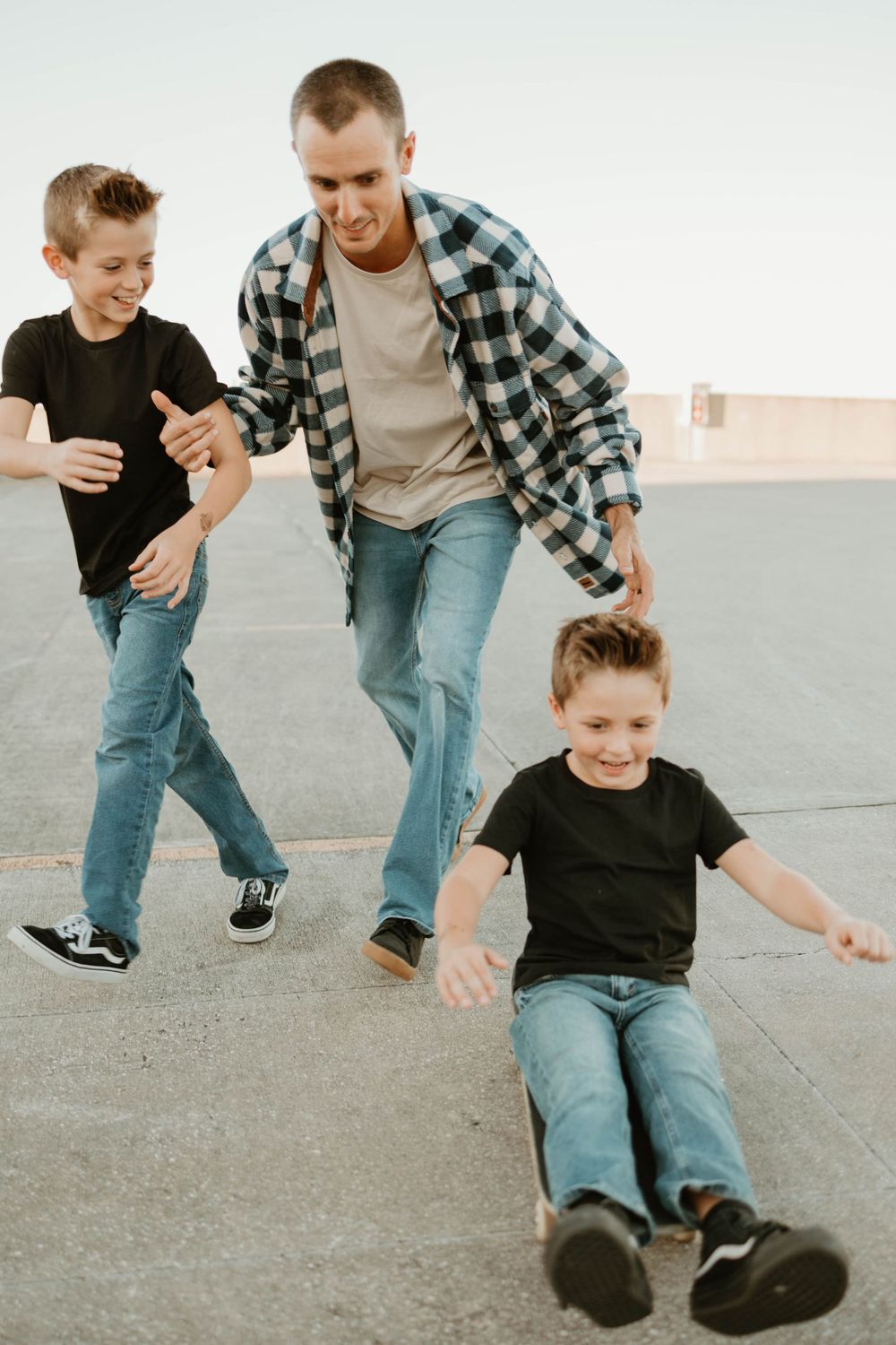 Action sequence of skateboarding practice with supportive guidance on a concrete surface.