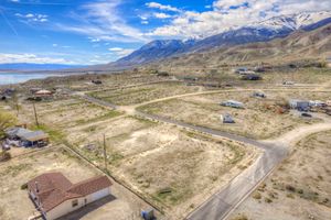 Aerial view of vacant land lot with mountain and lake backdrop in a rural Nevada desert community.