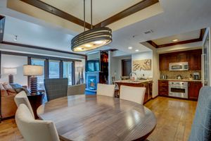 Open dining and kitchen area with cherry wood cabinetry, granite counters, and hardwood floors.