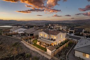 Aerial dusk view of luxury hillside homes with panoramic valley and reservoir views.