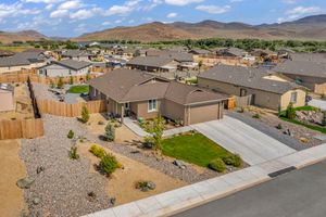 Aerial view of a modern single-story home with desert landscaping in a Nevada mountain community.