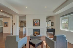 Elegant living room with gas fireplace, gray accent chairs, and hardwood floors.