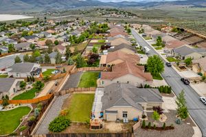 Aerial drone view of a residential neighborhood with fenced backyards and mountain views in Nevada.