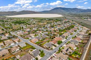 Aerial view of a Nevada subdivision with mountain backdrop and a dry lake bed visible beyond the homes.