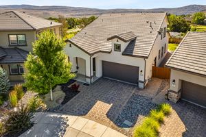 Aerial view of stucco home with paver driveway, two-car garage, and desert landscaping in Nevada.