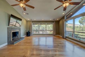 Spacious living room with hardwood floors, fireplace, and large panoramic windows.