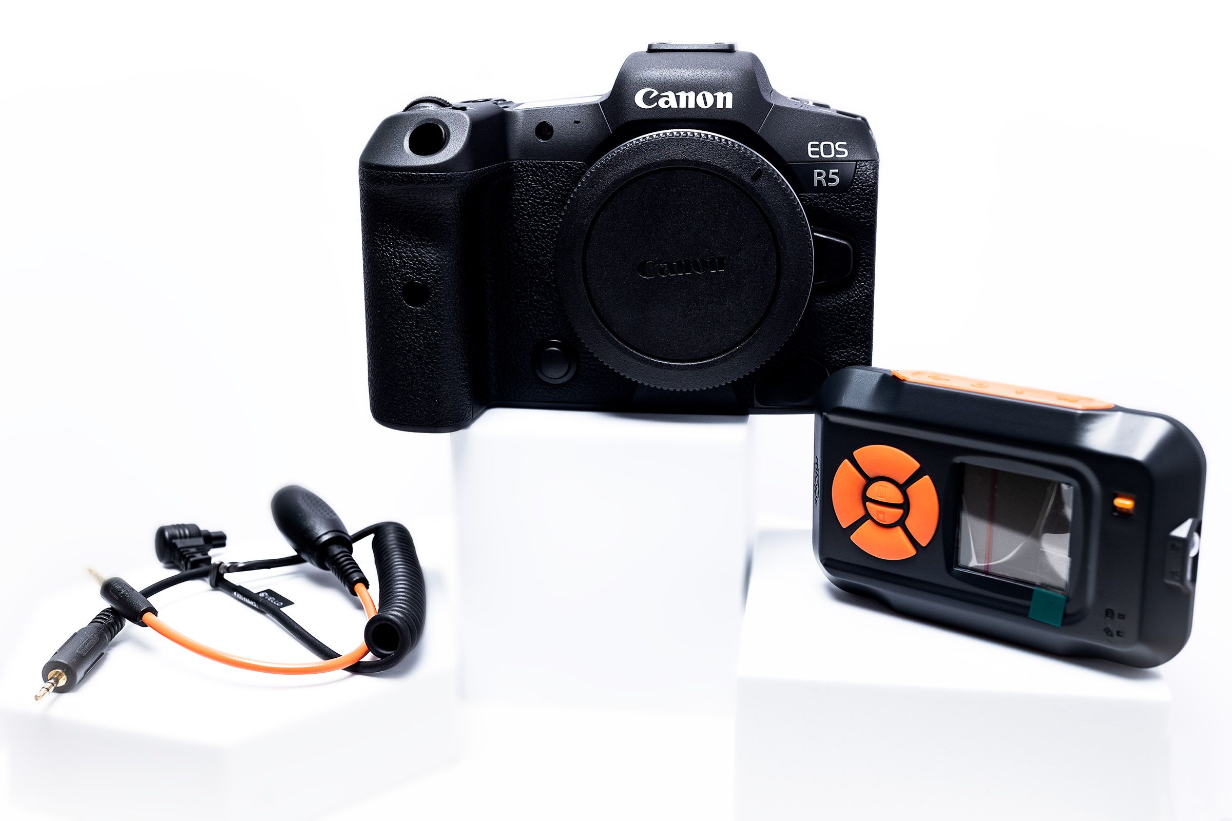 Canon R5 camera body with detached microphone and electronic trigger device.