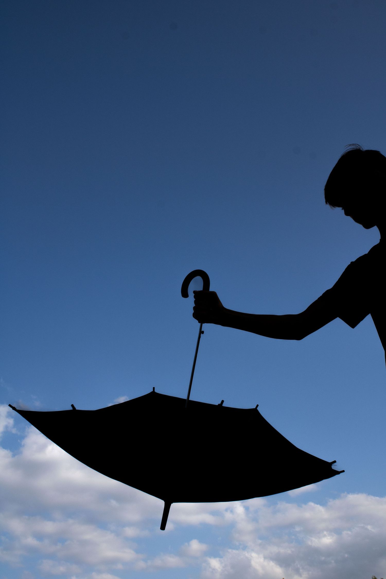 Silhouette of a boy holding an umbrella