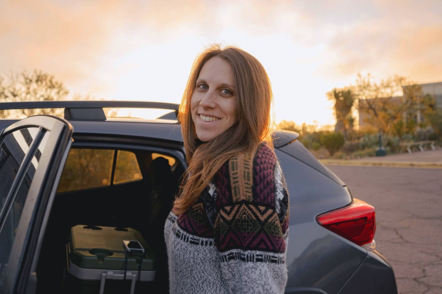 Woman in casual attire photographed during golden hour sunset.