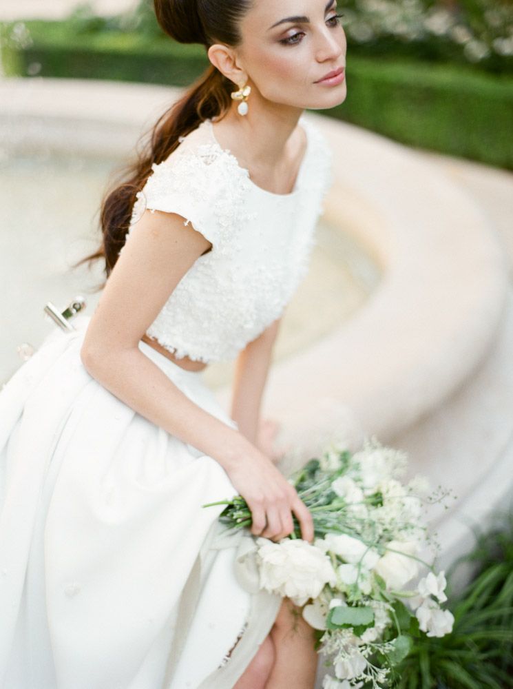 Robe de mariage blanche élégante avec des détails en dentelle et un délicat bouquet de fleurs blanches.