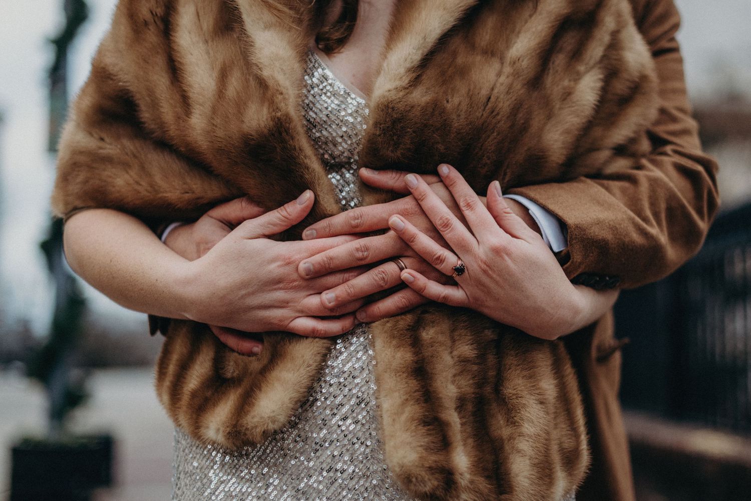 Close-up details of a brown fur coat and sparkly dress at a formal event.