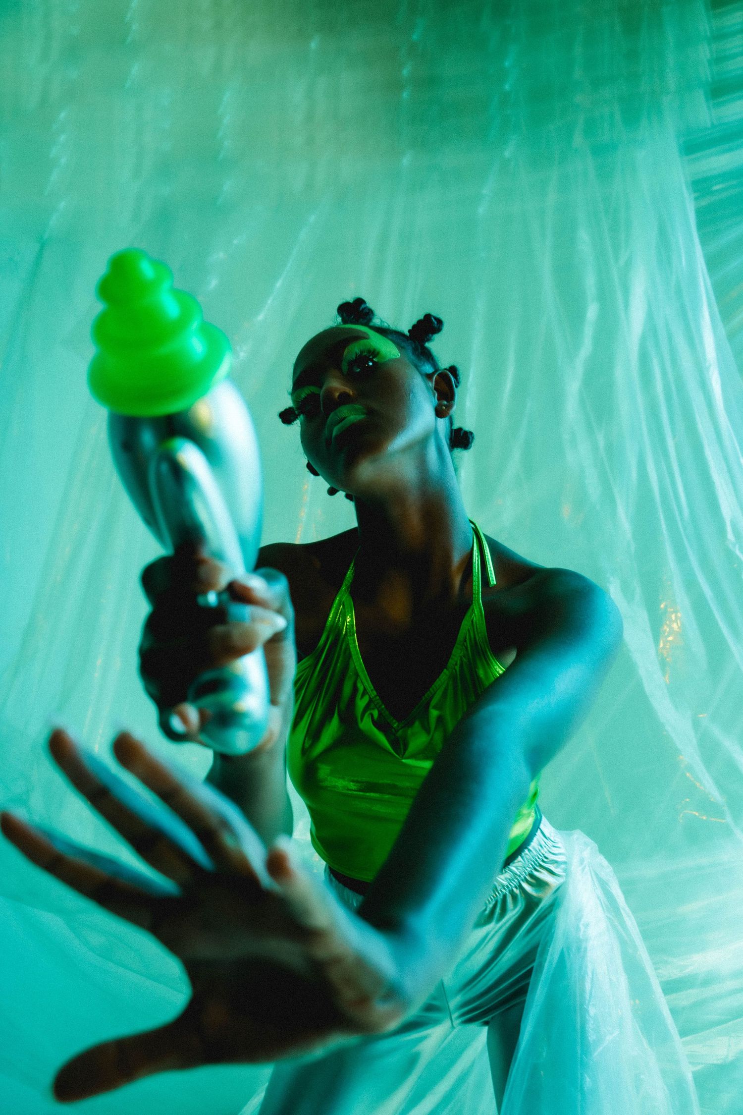 Artistic portrait series with green lighting and ethereal plastic sheet backdrop.