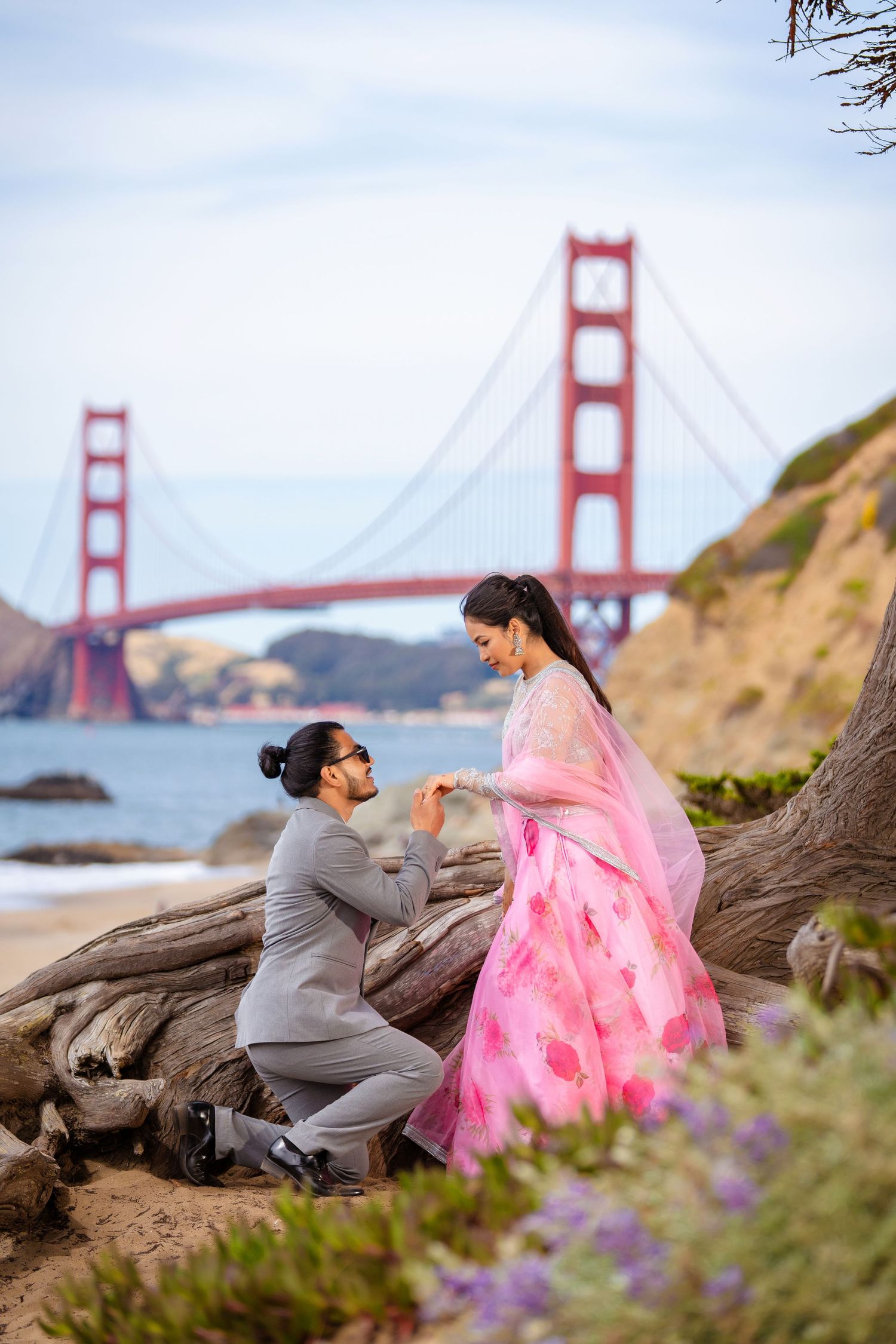 A romantic proposal moment captured in front of the iconic Golden Gate Bridge in San Francisco.