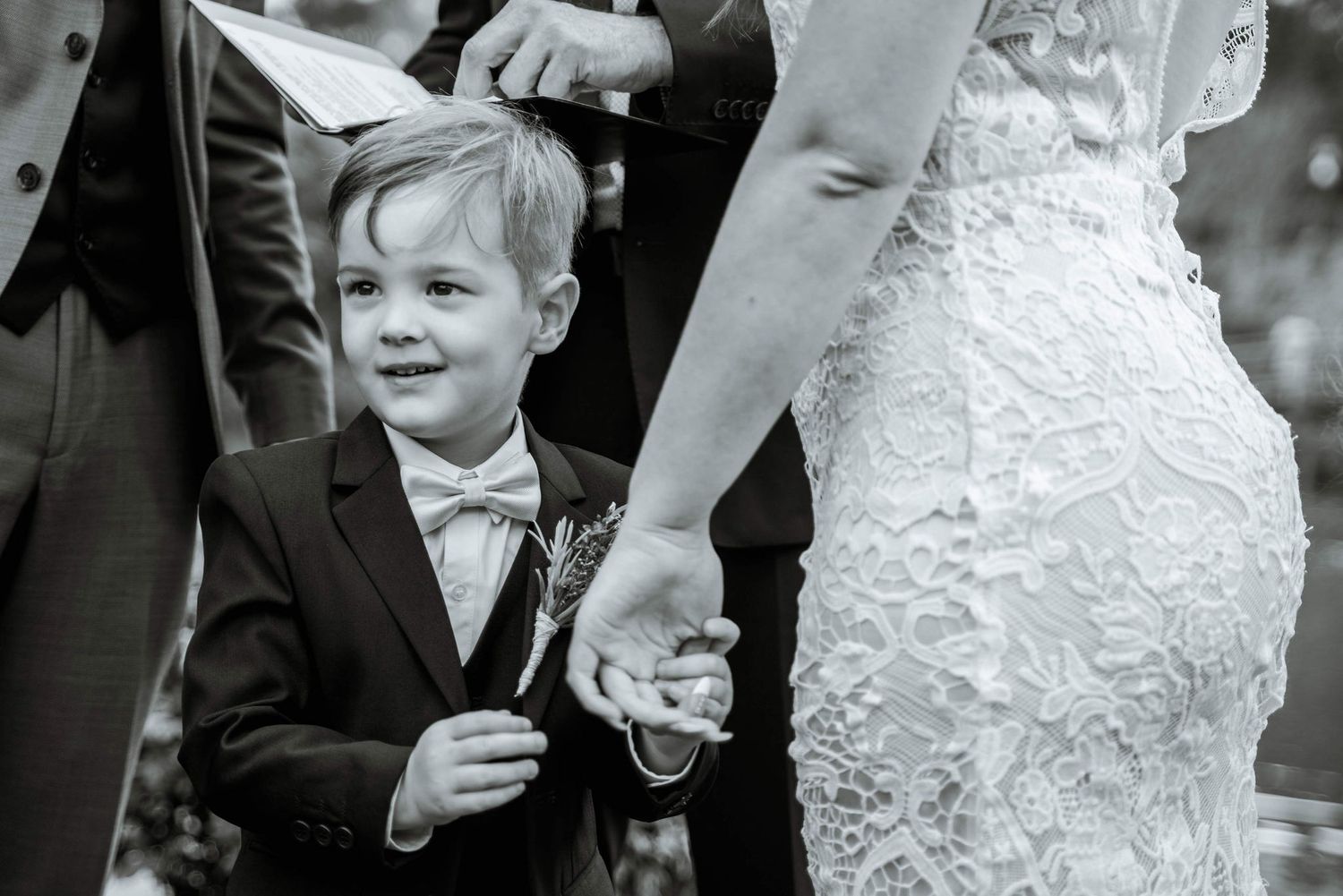 Black and white wedding photo showing formal attire and joyful expressions.