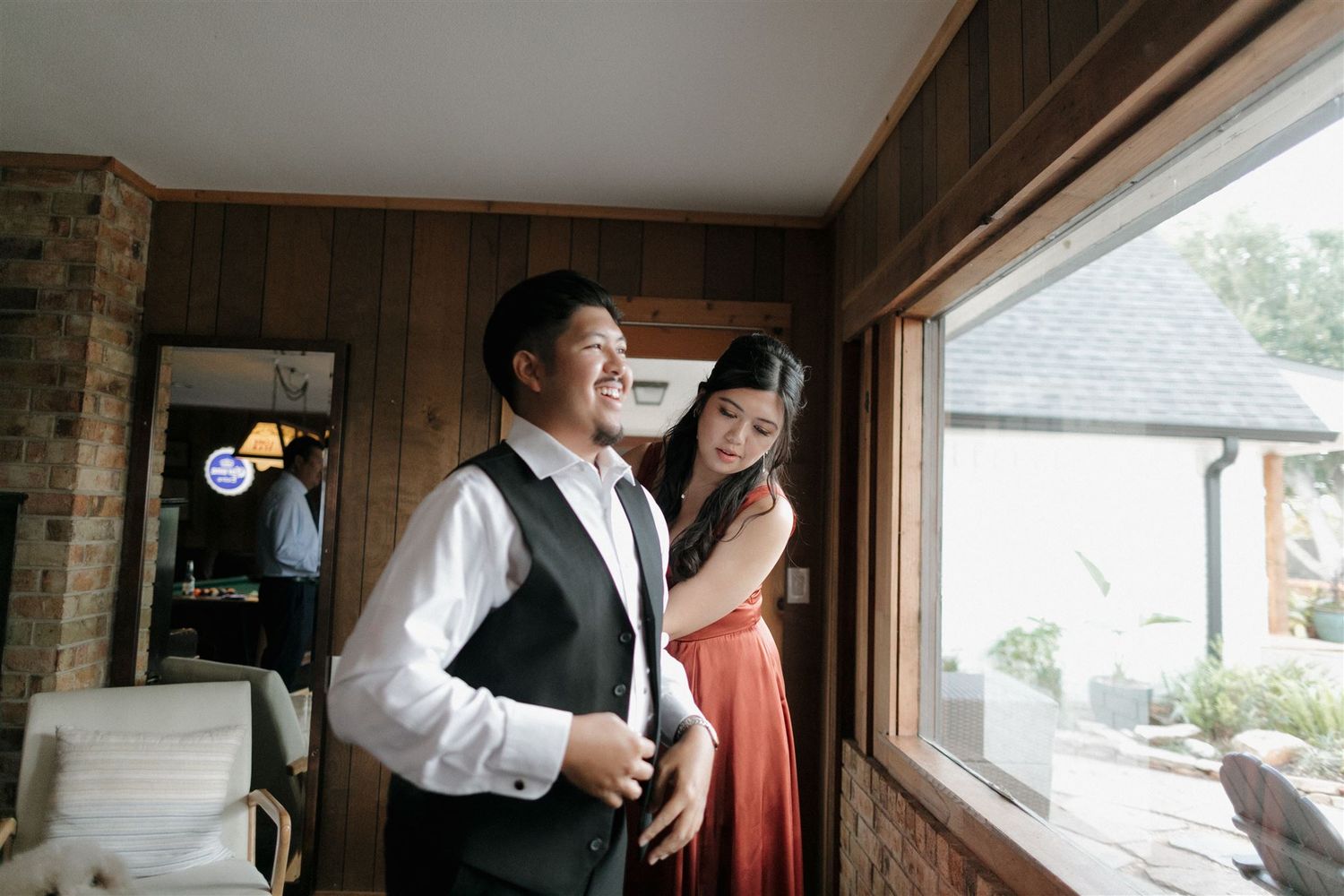 A formal preparation scene near a window in a wood-paneled room.