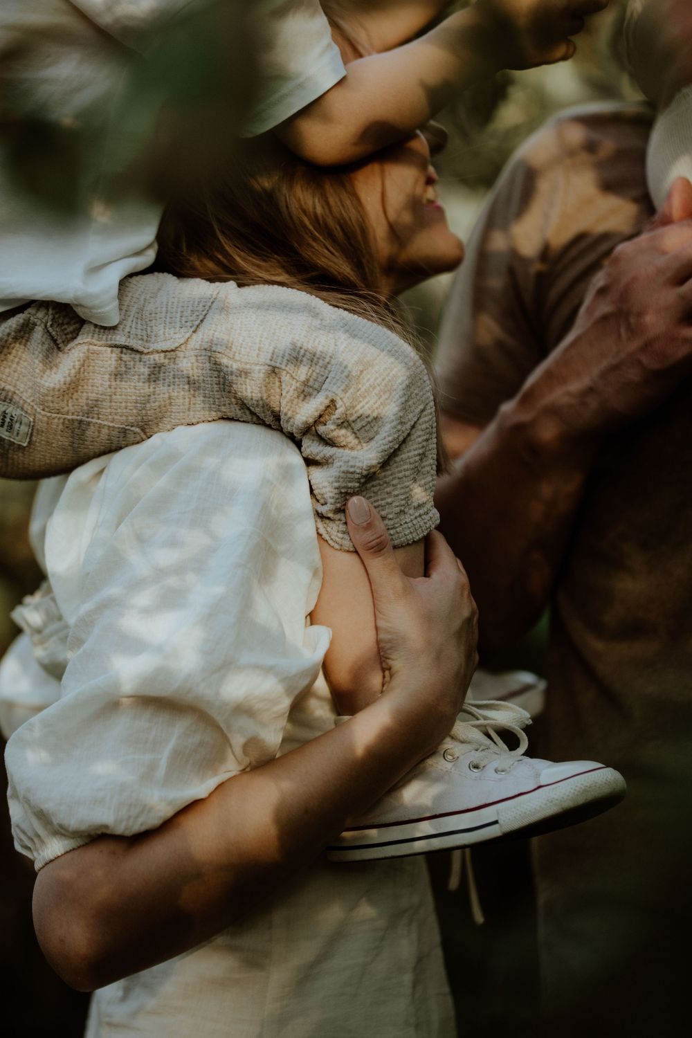 Tender candid moment captured in warm natural lighting outdoors.
