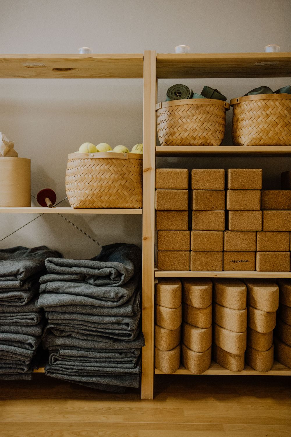 Organized wooden shelves with stacked jeans, woven baskets and storage boxes.