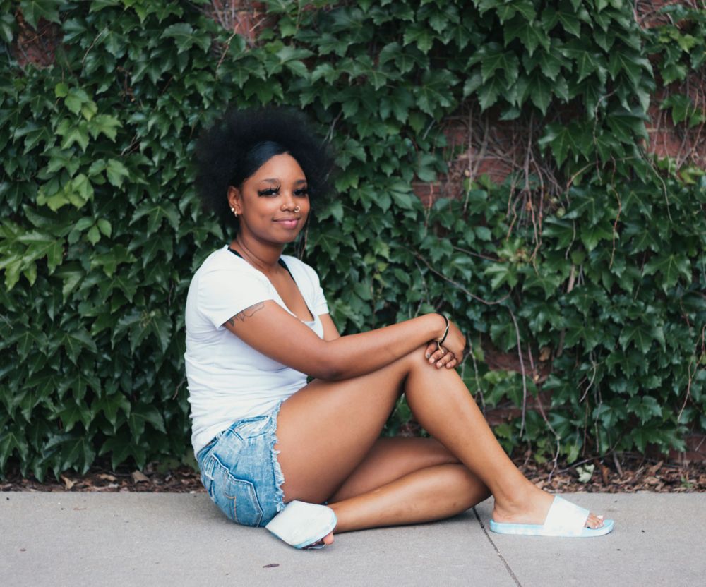 A casual summer portrait against a leafy green ivy wall.